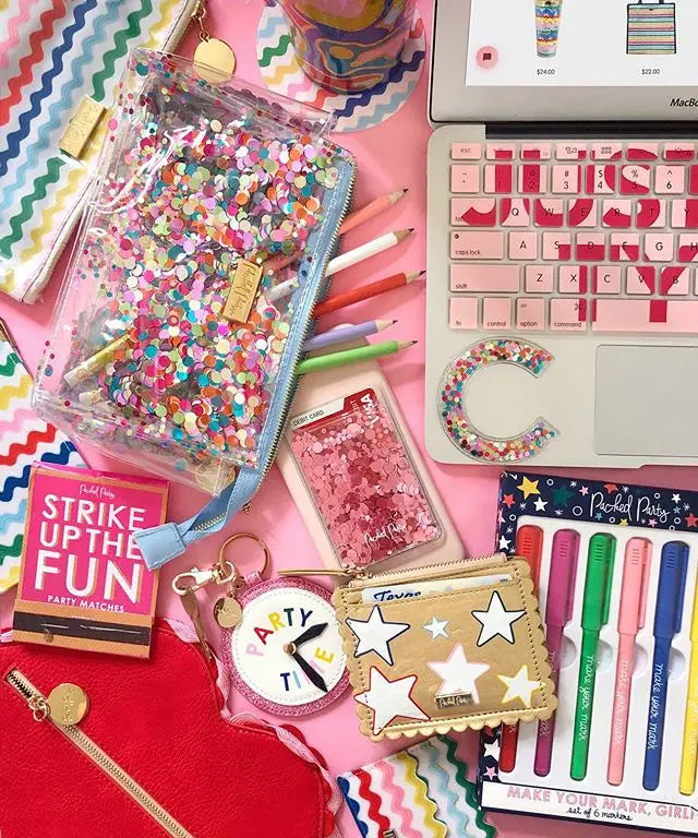 Kreativer Schreibtisch mit bunten Konfetti Stickern auf Notizbüchern und Accessoires – für DIY-Deko und Geschenke.